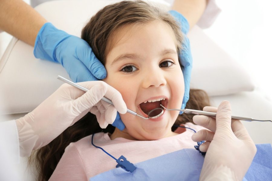Dentist examining girl’s teeth Dentist examining girl's teeth